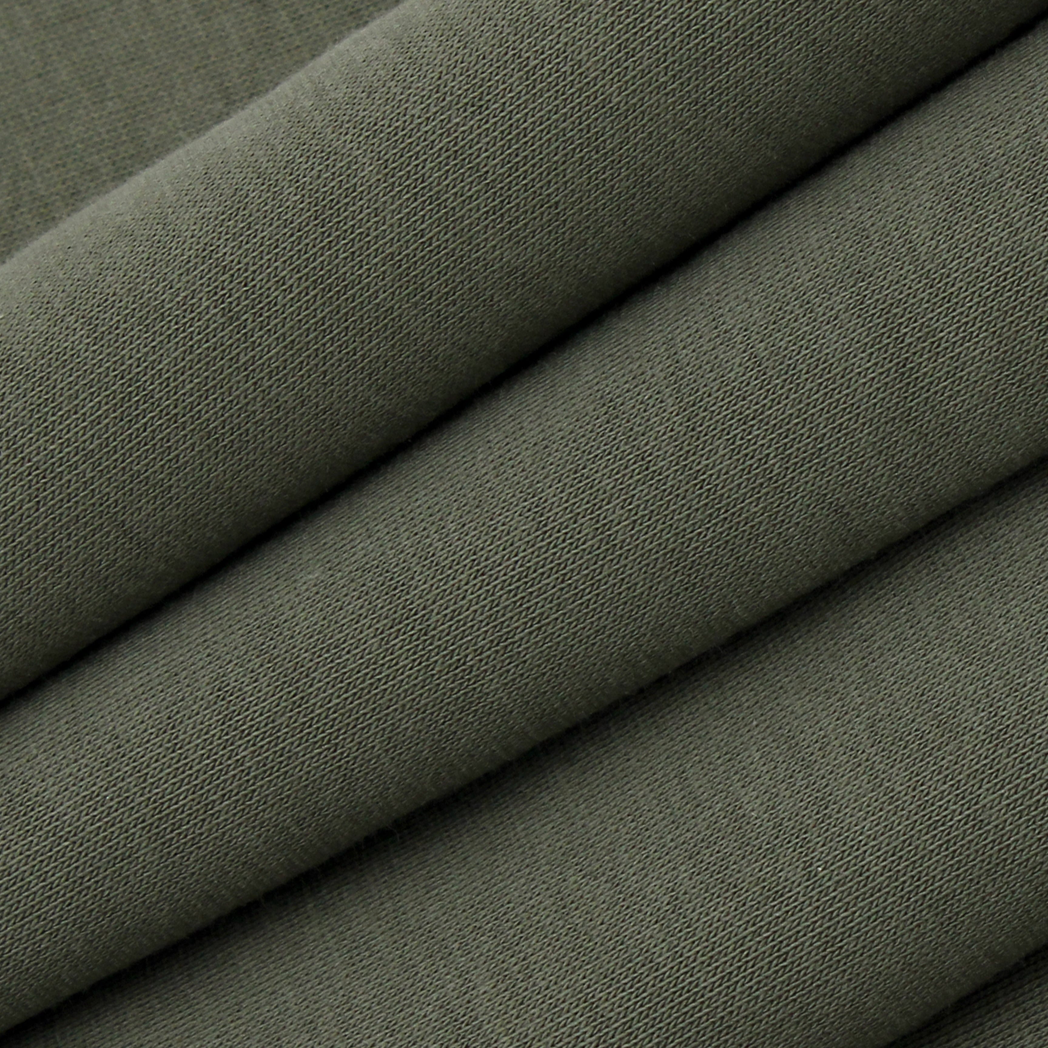 Stack of green fabric with a subtle pattern
